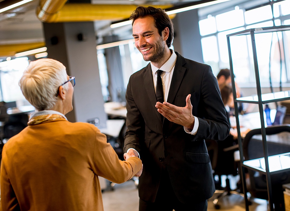 About Our Agency - Friendly Businessman Shakes Hands With a Colleague at an Office