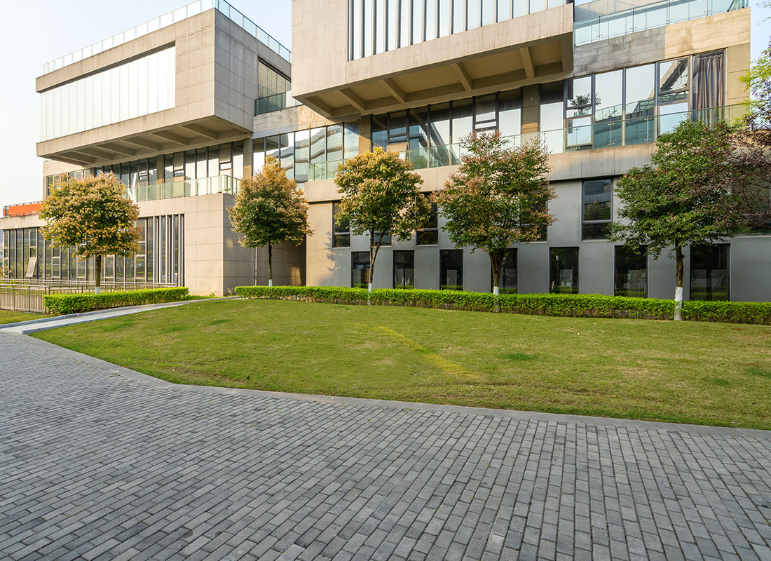Business Insurance - Exterior of a Modern Science Building With Small Trees in Front of it With a Brick Pattern Walkway